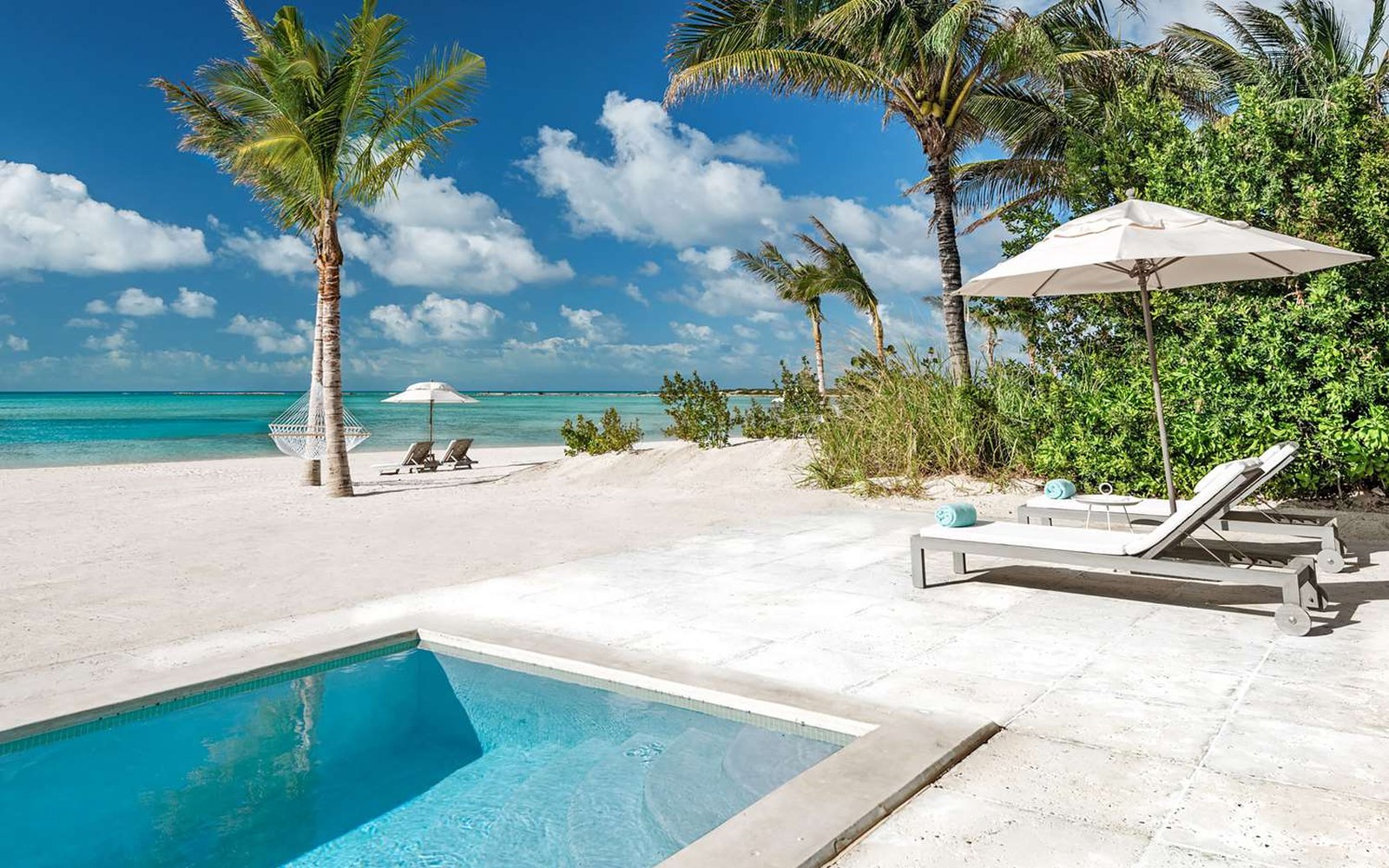 The plunge pool outside a Beachfront Bungalow, facing an empty stretch of sand
