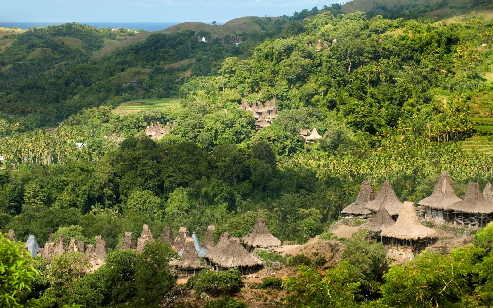 A traditional peaked-roof village in the hills near the resort, the kind the rides and treks pass through