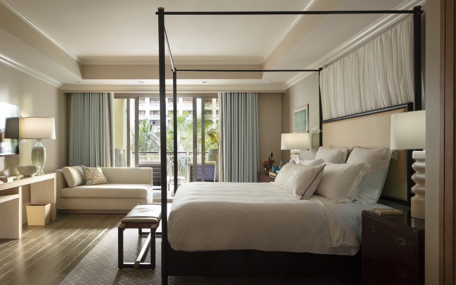 A Rosewood guest room: four-poster bed, residential-scale living space
