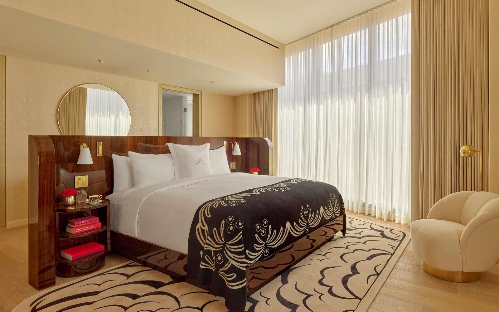 A suite bedroom: burl headboard, black-and-gold bed runner, cloud-pattern rug